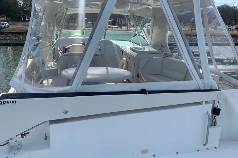  Yacht Photos Pics 2004 Carver 570 Voyager Pilothouse yacht interior with seating and table, docked by the water.