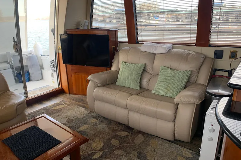  Yacht Photos Pics Interior of 2004 Carver 570 Voyager Pilothouse with beige sofa and TV.