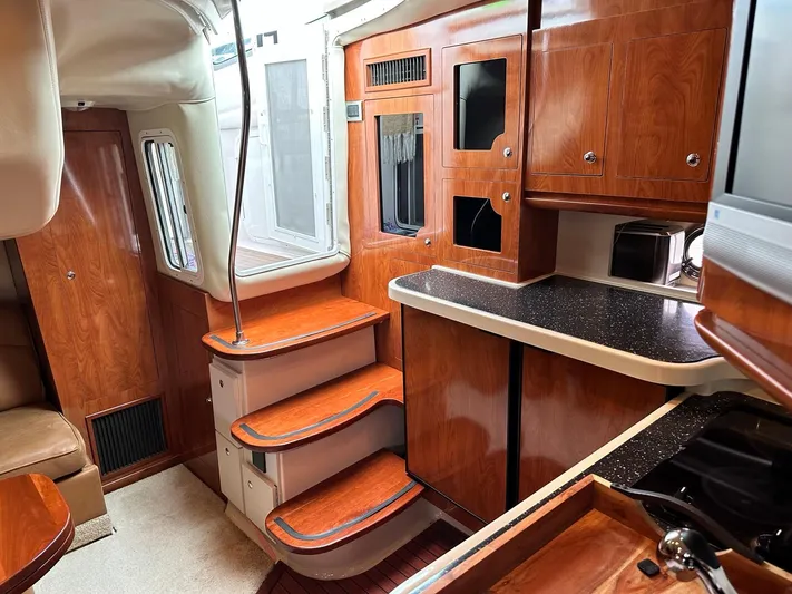  Yacht Photos Pics 2007 Four Winns 378 Vista yacht interior with wooden cabinetry and stairs.