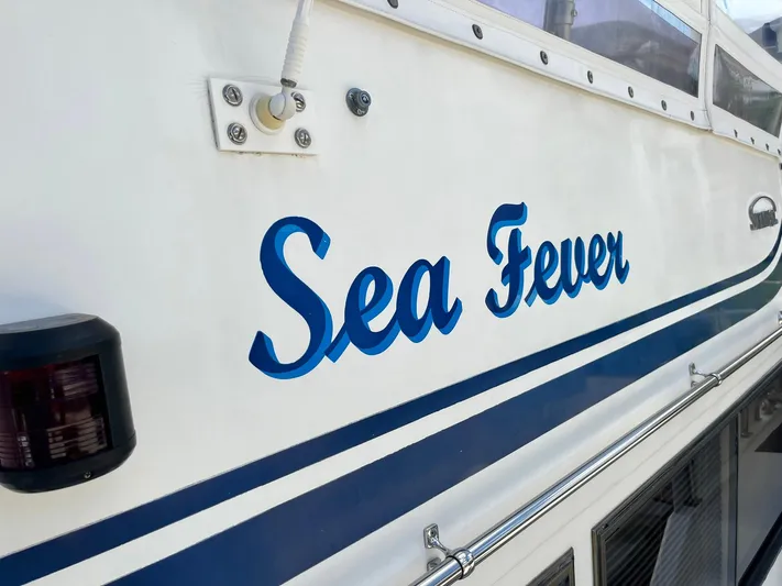 Sea Fever Yacht Photos Pics 1987 Symbol 44 Sun Deck MK II boat with "Sea Fever" name in blue lettering.