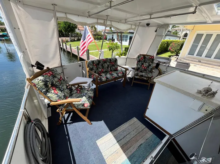 Sea Fever Yacht Photos Pics 1987 Symbol 44 Sun Deck MK II with floral seating, American flag, and waterfront view.