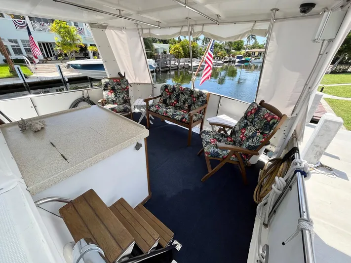 Sea Fever Yacht Photos Pics 1987 Symbol 44 Sun Deck MK II with floral seating, docked by a serene waterfront.