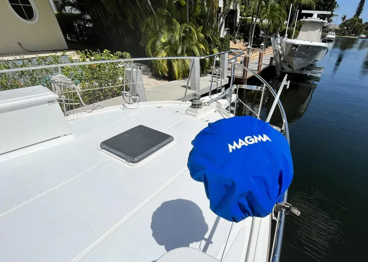 Sea Fever Yacht Photos Pics 1987 Symbol 44 Sun Deck MK II yacht with Magma grill cover, docked near lush greenery.