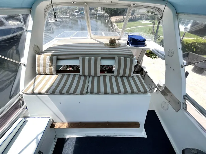 Sea Fever Yacht Photos Pics 1987 Symbol 44 Sun Deck MK II with striped seating and scenic marina view.