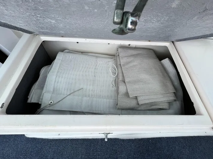 Sea Fever Yacht Photos Pics Storage compartment with folded gray fabric on a 1987 Symbol 44 Sun Deck MK II boat.
