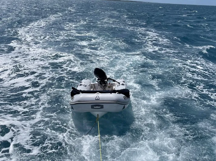 Sea Fever Yacht Photos Pics A small boat being towed on open water, behind a 1987 Symbol 44 Sun Deck MK II.