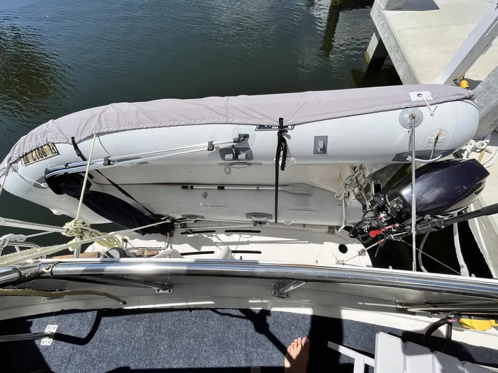 Sea Fever Yacht Photos Pics 1987 Symbol 44 Sun Deck MK II with dinghy on deck, docked by the water.