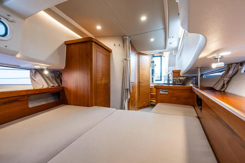 Rylea Rose Yacht Photos Pics Luxurious interior of 2021 Nimbus C11 yacht with wooden furnishings and cozy bedding.