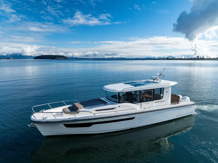 Rylea Rose Yacht Photos Pics Nimbus C11 2021 boat cruising on a serene lake under a clear blue sky.