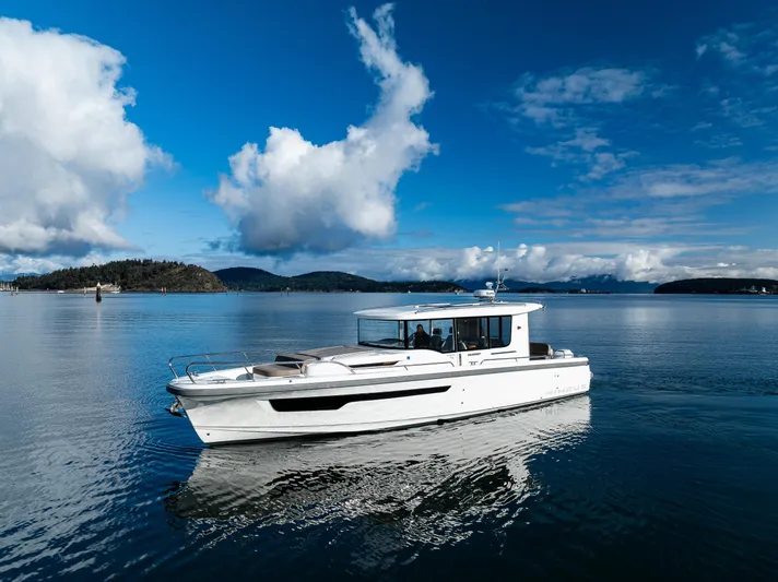 Rylea Rose Yacht Photos Pics Nimbus C11 2021 boat cruising on a serene lake under a blue sky.