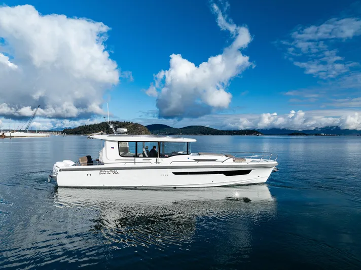 Rylea Rose Yacht Photos Pics Nimbus C11 2021 boat cruising on a serene lake under a blue sky.
