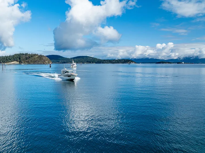 Rylea Rose Yacht Photos Pics Nimbus C11 boat cruising on a serene blue lake under a partly cloudy sky.