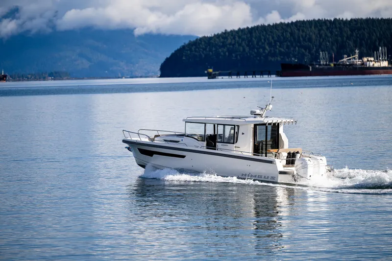 Rylea Rose Yacht Photos Pics Nimbus C11 2021 boat cruising on a serene lake with forested hills in the background.