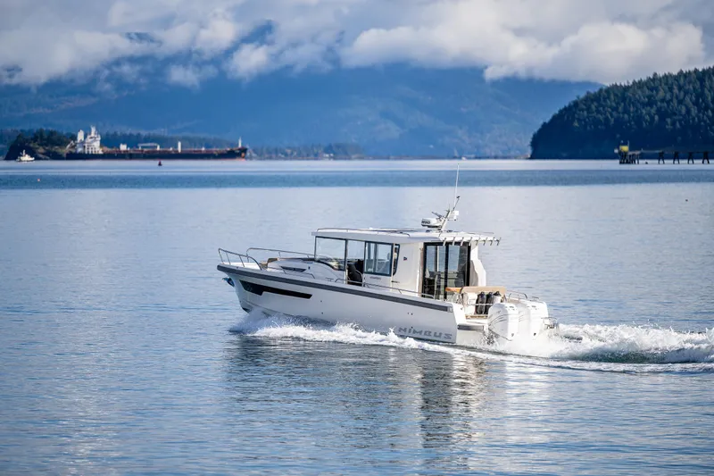 Rylea Rose Yacht Photos Pics Nimbus C11 2021 boat cruising on a serene lake with mountains in the background.