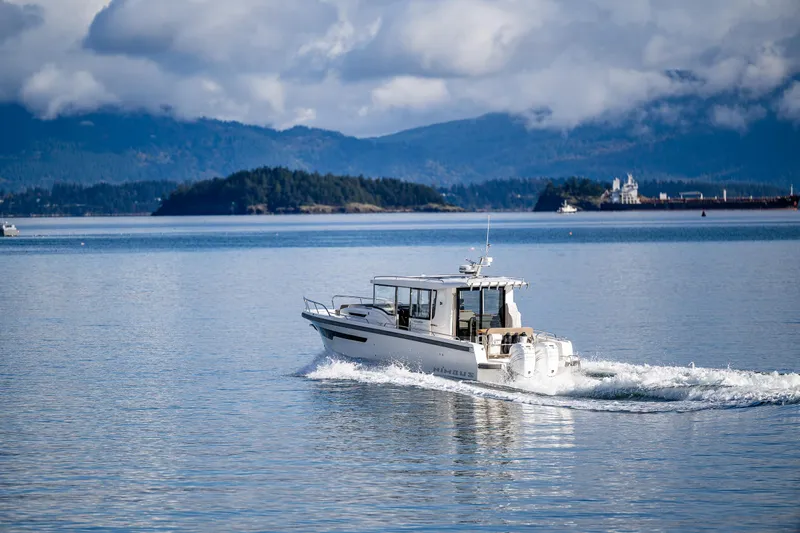 Rylea Rose Yacht Photos Pics Nimbus C11 2021 boat cruising on a serene lake with mountainous backdrop.