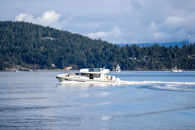 Rylea Rose Yacht Photos Pics Nimbus C11 boat cruising on a serene lake with forested hills in the background.