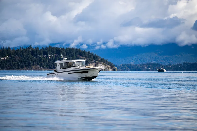 Rylea Rose Yacht Photos Pics Nimbus C11 boat cruising on a serene lake with forested hills in the background.