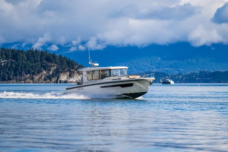 Rylea Rose Yacht Photos Pics Nimbus C11 2021 boat cruising on a scenic lake with forested hills in the background.