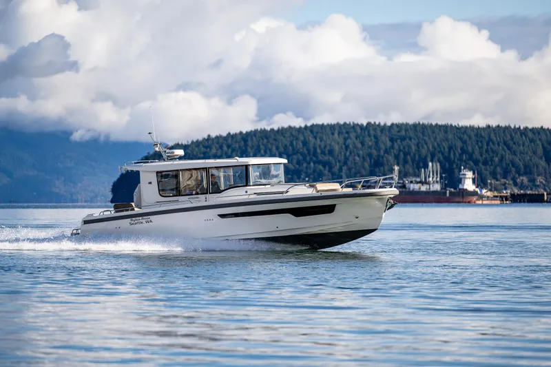 Rylea Rose Yacht Photos Pics Nimbus C11 2021 boat cruising on a scenic lake with forested hills in the background.