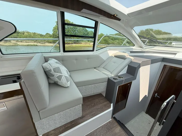2023 Cruisers 42 Cantius Yacht Photos Pics Luxurious interior of 2023 Cruisers Yachts 42 Cantius with plush seating and scenic window view.