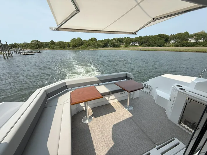 2023 Cruisers 42 Cantius Yacht Photos Pics 2023 Cruisers Yachts 42 Cantius aft deck with seating, tables, and scenic water view.