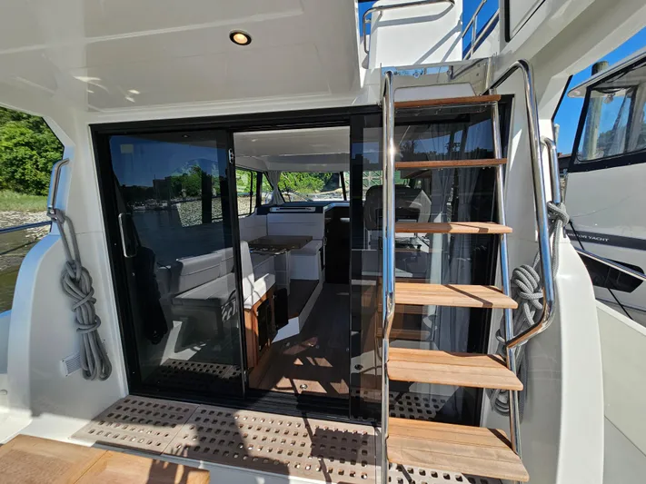  Yacht Photos Pics 2024 Beneteau Antares 12 yacht interior with wooden stairs and glass doors.
