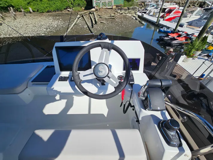  Yacht Photos Pics Helm of 2024 Beneteau Antares 12, featuring modern controls and steering wheel.