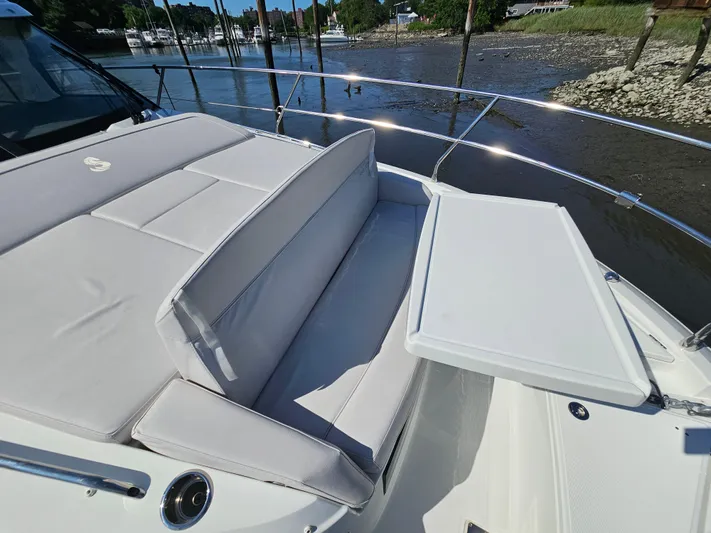  Yacht Photos Pics 2024 Beneteau Antares 12 boat with cushioned seating and table on deck.