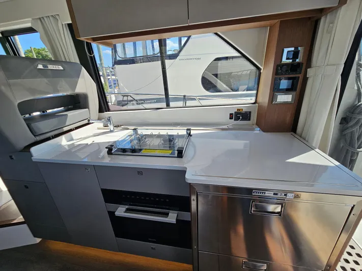  Yacht Photos Pics Modern kitchen interior of 2024 Beneteau Antares 12 yacht with stove and oven.