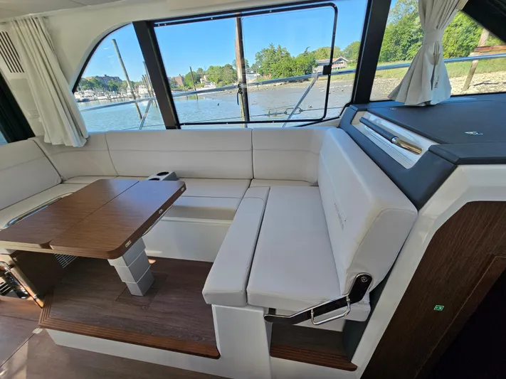  Yacht Photos Pics Luxurious interior of 2024 Beneteau Antares 12 yacht with elegant seating and wooden table.
