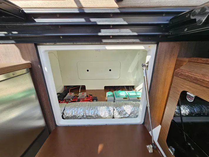  Yacht Photos Pics 2024 Beneteau Antares 12 interior storage compartment with visible wiring and insulation.