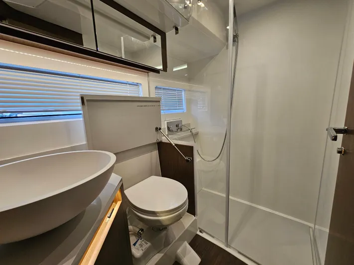 Yacht Photos Pics Modern bathroom in 2024 Beneteau Antares 12 yacht with shower, sink, and toilet.