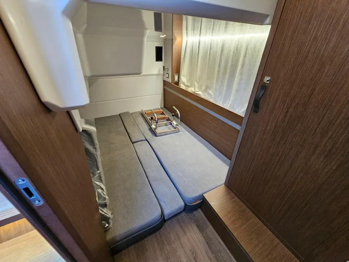  Yacht Photos Pics 2024 Beneteau Antares 12 cabin interior with modern wood finish and cozy seating.