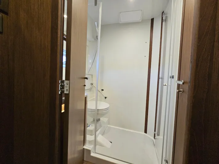  Yacht Photos Pics 2024 Beneteau Antares 12 bathroom with modern design and wooden accents.