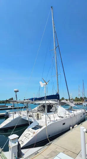  Yacht Photos Pics Lagoon 42 catamaran, 1994 model, docked at a marina under a clear blue sky.