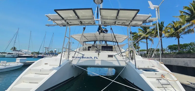  Yacht Photos Pics 1994 Lagoon 42 catamaran docked in Miami Beach marina, featuring solar panels and clear blue skies.