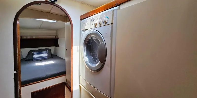  Yacht Photos Pics Laundry area and cozy bedroom in 1994 Lagoon 42 yacht interior.