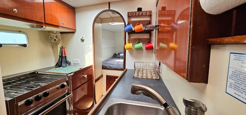  Yacht Photos Pics Interior of 1994 Lagoon 42 yacht kitchen with stove, sink, and colorful mugs.