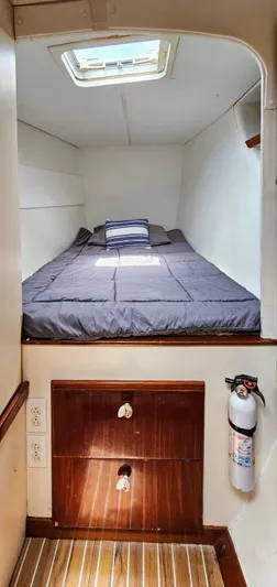  Yacht Photos Pics Cozy cabin interior of 1994 Lagoon 42 catamaran with bed, skylight, and wooden storage.
