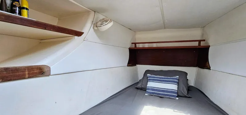  Yacht Photos Pics Cozy cabin interior of a 1994 Lagoon 42 sailboat with shelves and bedding.