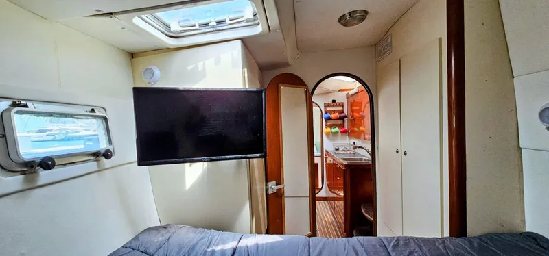  Yacht Photos Pics Interior of 1994 Lagoon 42 yacht with TV, bed, and view into kitchen area.