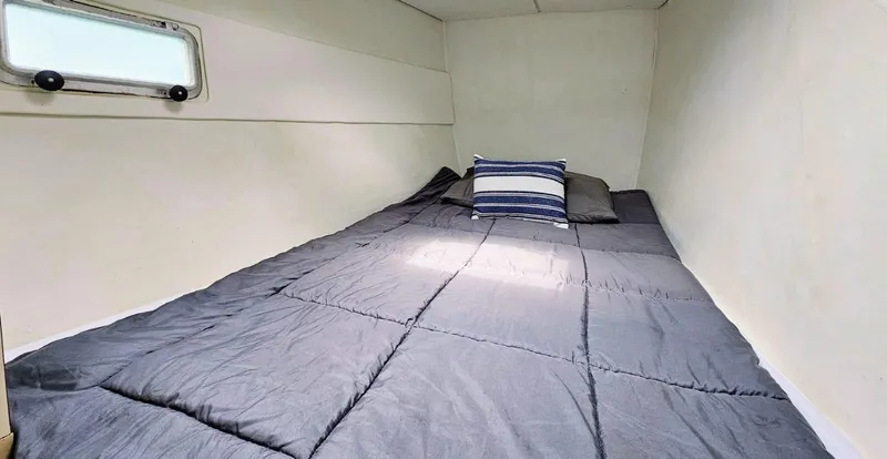  Yacht Photos Pics Cozy cabin bed in 1994 Lagoon 42 sailboat with window and pillows.