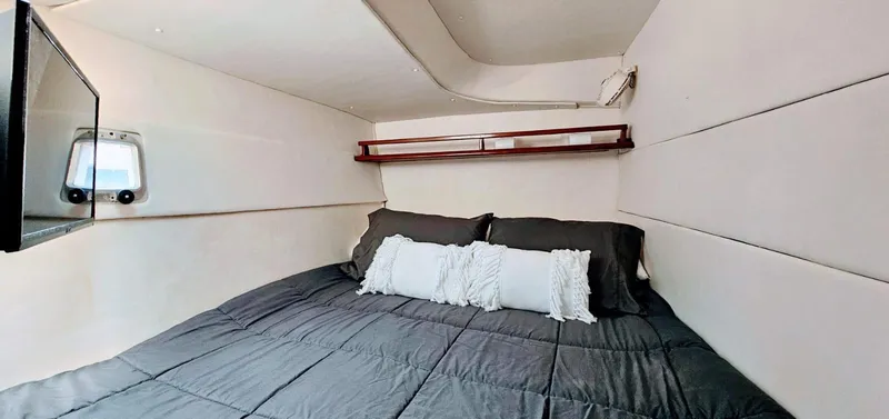  Yacht Photos Pics Cozy bedroom interior of 1994 Lagoon 42 yacht with modern bedding and wall-mounted TV.