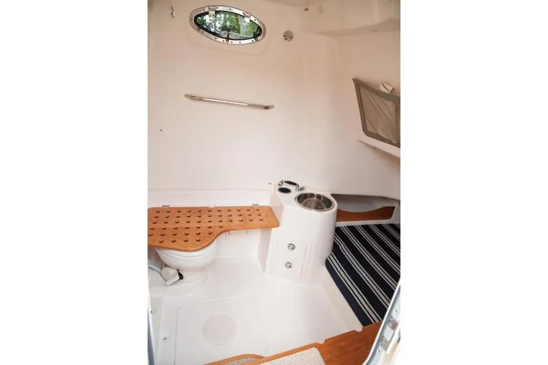  Yacht Photos Pics Manufacturer Provided Image: 2015 Grady-White Canyon 336 boat interior with toilet and wooden bench.
