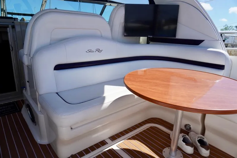  Yacht Photos Pics 2007 Sea Ray 38 Sundancer interior with white seating, wooden table, and mounted TV.