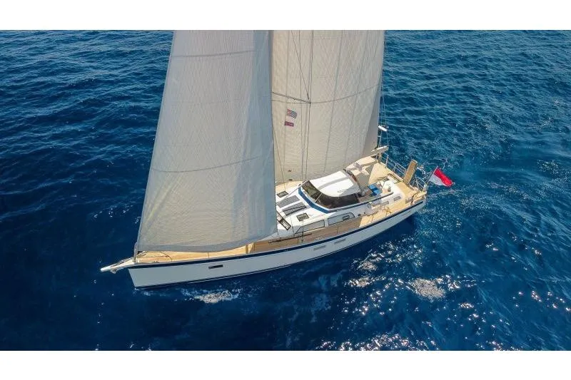  Yacht Photos Pics 2023 Hallberg-Rassy 50 sailing yacht on open blue sea, aerial view.