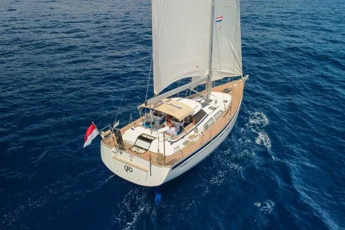  Yacht Photos Pics 2023 Hallberg-Rassy 50 yacht sailing on open blue sea, elegant design.
