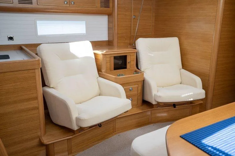  Yacht Photos Pics Luxurious 2023 Hallberg-Rassy 50 yacht interior with plush white seating and elegant wood finish.