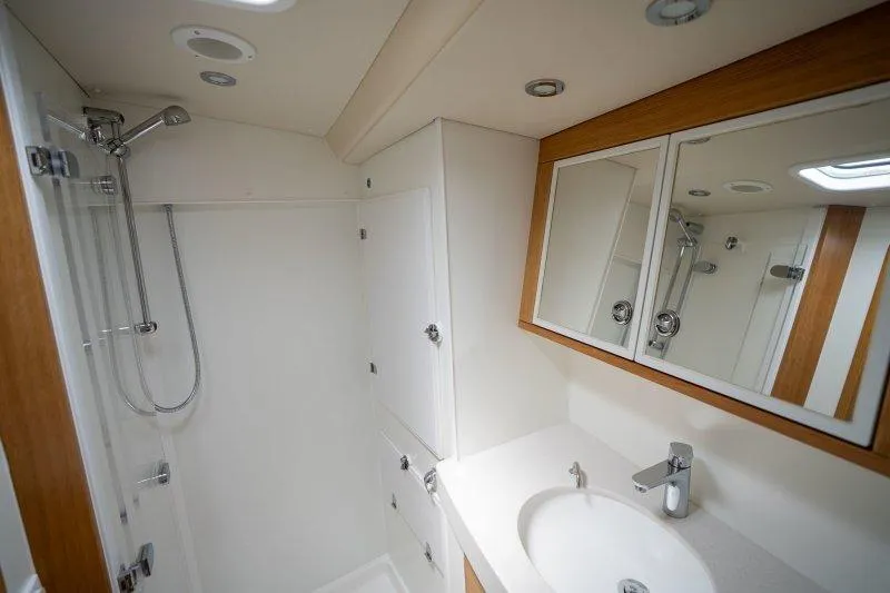  Yacht Photos Pics Modern bathroom in 2023 Hallberg-Rassy 50 yacht with shower and vanity.