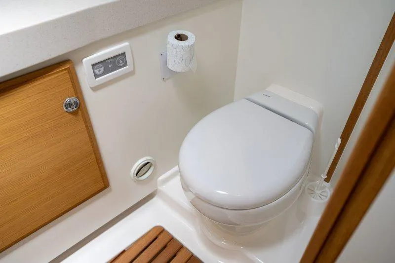  Yacht Photos Pics Modern bathroom in 2023 Hallberg-Rassy 50 yacht with sleek toilet and wooden accents.